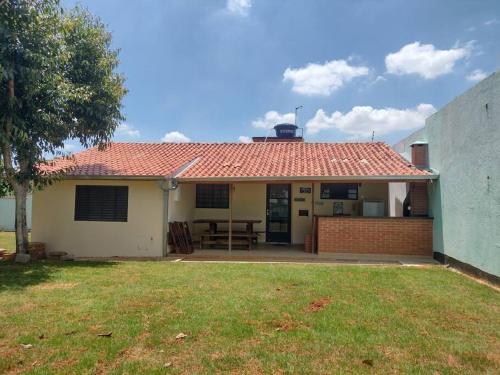 因达亚图巴Casinha Charmosa & Rústica的一座红色屋顶的房子和一个院子
