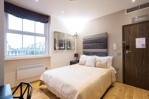 伦敦太空公寓的一间卧室设有一张大床和一个窗户。