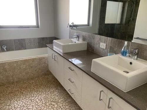 扬巴The Residence at MobyDick Resort的浴室设有2个水槽、镜子和浴缸。