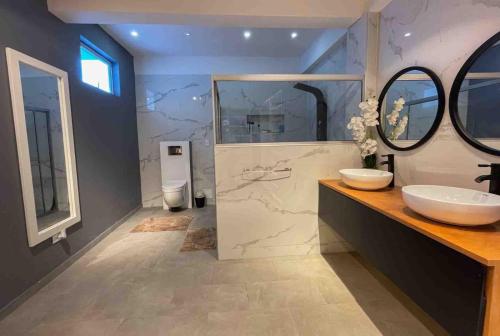 莱蒂西亚Rio Hotel lagos的一间带两个盥洗盆和大镜子的浴室