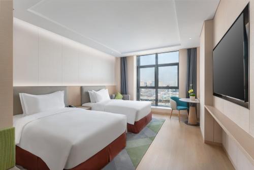 太原太原阳光假日酒店的酒店客房设有两张床和一台平面电视。