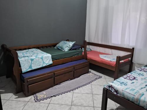 伊塔尼亚恩Hostel do Enzo的带窗户的客房内设有两张单人床。