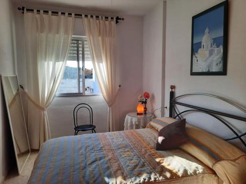 埃尔波提尔Mi bonito apartamento del Portil的一间卧室设有一张床和一个窗口