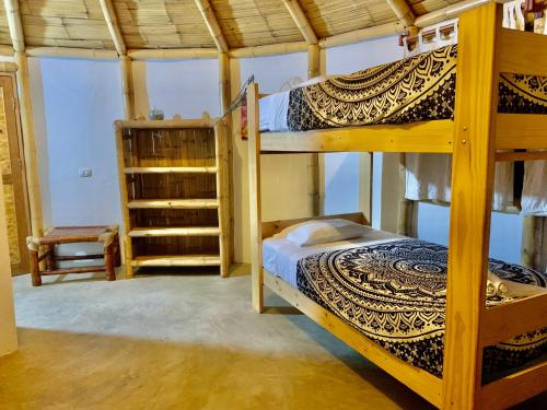 卡诺阿斯德蓬萨尔Waltako Beach Culture的一间卧室配有两张双层床和椅子