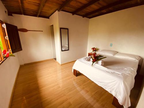 努基Cabañas Iracas del Mar的卧室配有白色的床,铺有木地板