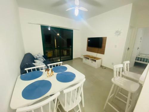 卡拉瓜塔图巴Apartamento beira mar vista para montanha em Massaguaçú的一间配备有白色桌椅的用餐室
