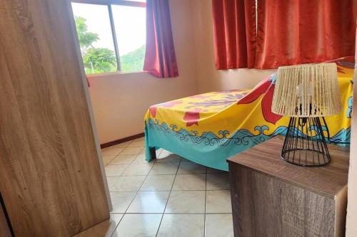 TaputapuapeaVaiana Home 2 - bord de lagon的一间卧室配有一张带彩色毯子的床