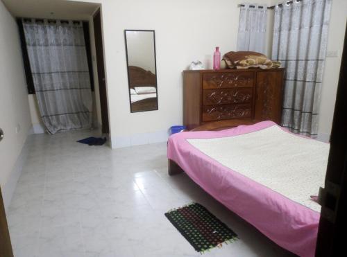 达卡Rent Room in Bashundhara R A near US Embassy的一间卧室配有一张床、梳妆台和镜子