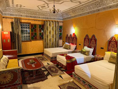 拉巴特Riad Dar Doura的酒店客房设有两张床和一张桌子。