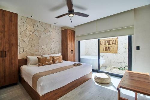 图卢姆Departamento en Tulum Jade的一间卧室设有一张床和石墙