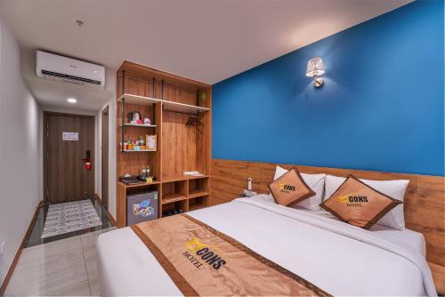 边和Bcons PS Hotel and Apartment- Newly Opened Hotel的一间卧室设有一张蓝色墙壁的大床