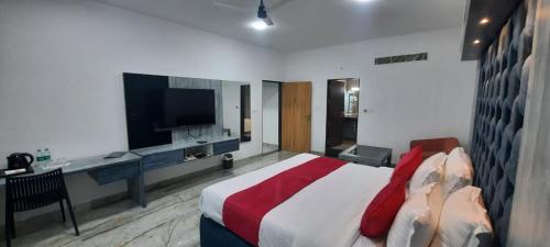 NizāmābādHotel krishna的一间卧室配有一张床、一张书桌和一台电视
