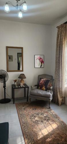 卢萨卡Treegate HMS Gardens的客厅配有椅子和镜子