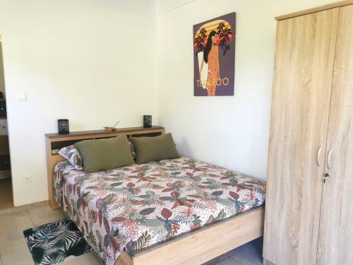 乌图罗阿Fare Kairos的卧室配有一张床,墙上挂有绘画作品