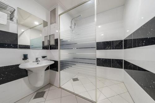 首尔Hotel Signature的白色的浴室设有水槽和淋浴。