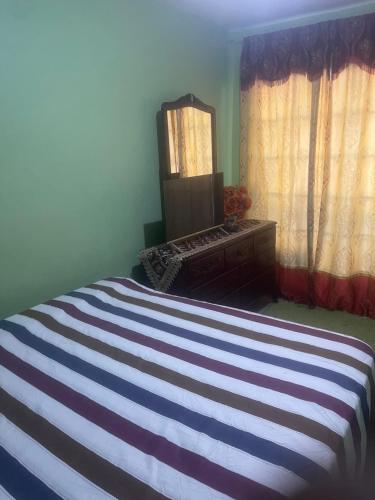 金斯敦Jamaican J Home的一间卧室配有一张带镜子和梳妆台的床