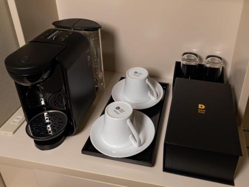东京东京秋叶原菲诺贝斯特韦斯特酒店的一个带两个杯子的柜台和咖啡壶