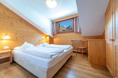 塞尔瓦迪加尔代纳山谷Week End Senoner的一间卧室设有一张大床和一个窗户。