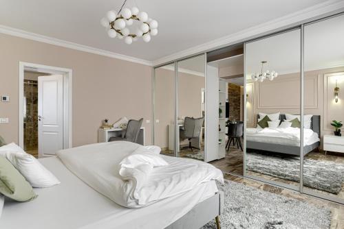 阿拉德Sika Royal Central Apartment的白色卧室配有床和镜子
