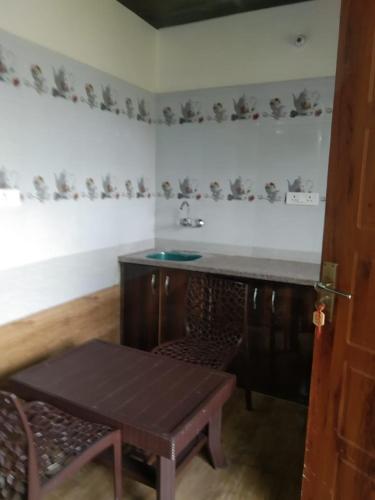 巴德里纳特Badrinath B V by prithvi yatra hotels的厨房配有桌子、水槽和桌子