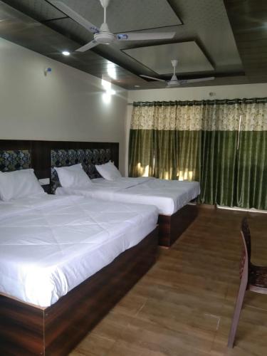 巴德里纳特Badrinath B V by prithvi yatra hotels的一间卧室设有两张床和窗户。