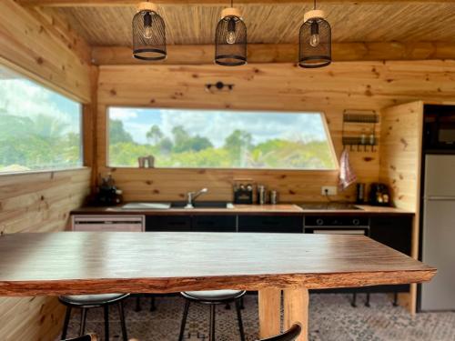利富岛Ô Naturel Lodge Lifou的厨房配有木桌和大窗户。
