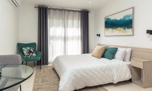 阿克拉Luxurious loft space Available的一间卧室设有一张大床和一张玻璃桌