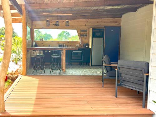 利富岛Ô Naturel Lodge Lifou的开放式甲板,配有厨房和桌子