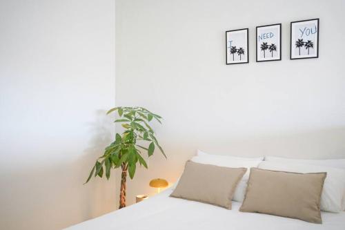 夏约法Studio 10 / Tenerife的卧室配有带枕头和植物的白色床