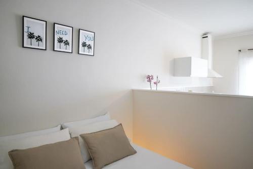 夏约法Studio 10 / Tenerife的白色的房间,设有一张床,墙上有三张照片