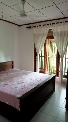 贝鲁沃勒Praveen villa的一间设有床铺的卧室,位于带窗户的房间内