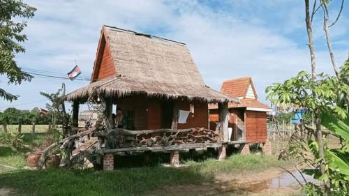 Phumĭ Puŏk ChăsMeta Homestay的一间有稻草屋顶的小房子