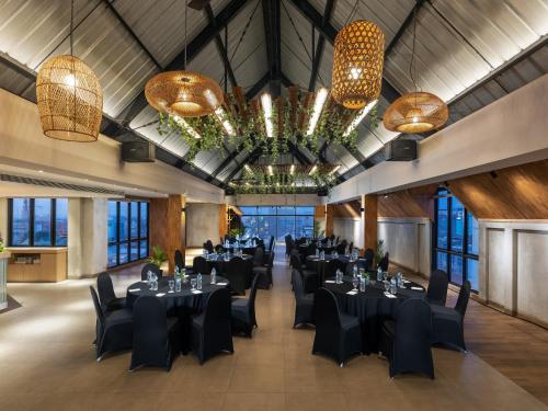 日惹Aveta Hotel Malioboro的宴会厅配有黑色桌椅和吊灯