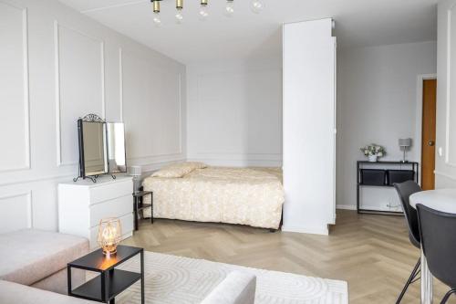 万塔30m2 studio - 500m from train station to Airport and Helsinki city centre的白色的客厅配有床和桌子