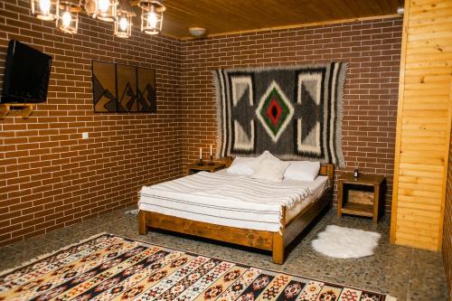 米戈韦Karpaty Migovo的卧室配有砖墙内的床铺