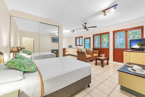 凯恩斯热带海湾乡村酒店的一间卧室设有一张床和一间客厅。