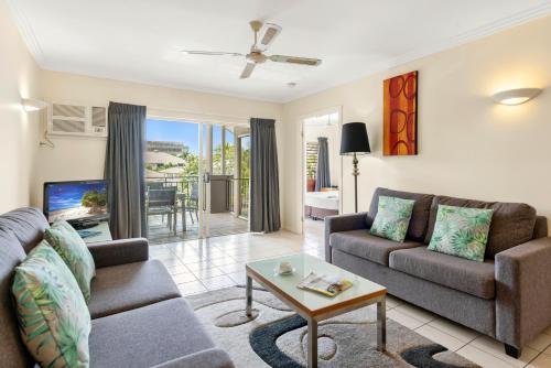 凯恩斯热带海湾乡村酒店的客厅配有沙发和桌子