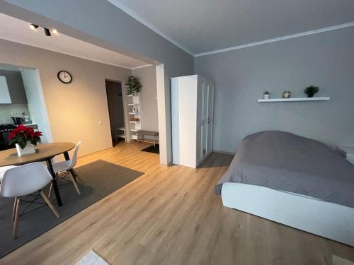 里加Cozy apartment close to Riga Airport的一间卧室配有一张床铺和一张桌子,还有一间用餐室