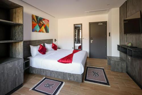 布米尔达斯coast hotel的卧室配有带红色枕头的大型白色床