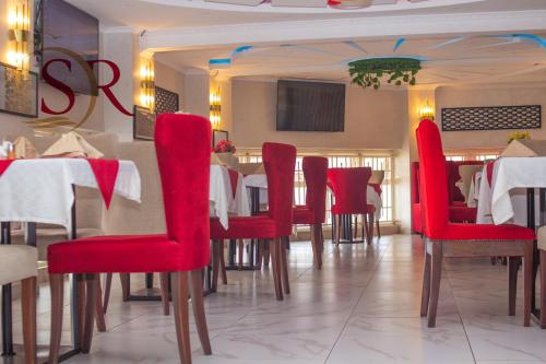 基苏木Selella Resort的一间用餐室,配有红色的椅子和桌子