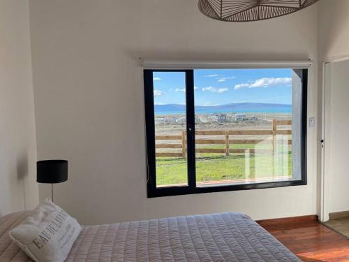 埃尔卡拉法特Cabaña Patagonia的一间卧室设有一张床和一个大窗户