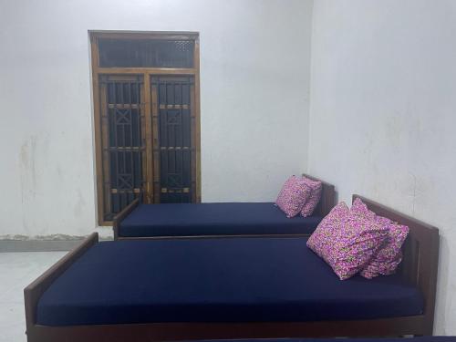 EravurEVR Home Stay的两张带紫色枕头的床,位于一间房间内