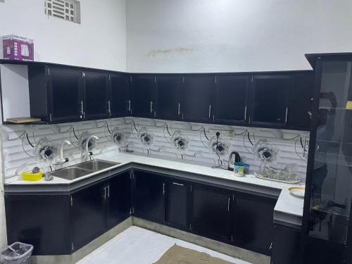 EravurEVR Home Stay的厨房配有黑色橱柜和水槽