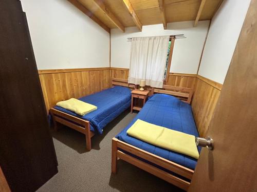 里坎雷Cabañas El Boldo的小房间设有两张床和窗户