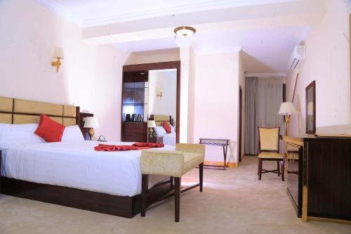 亚的斯亚贝巴Sunland International Hotel的卧室配有一张白色大床和一张书桌