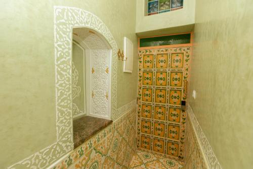 丹吉尔Colorful traditional Riad w/views of Spain的浴室设有一扇门,内有镜子