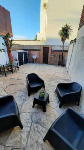维拉卡洛斯帕兹Meraki Classic的一座配有黑色椅子和桌子的庭院和一座建筑