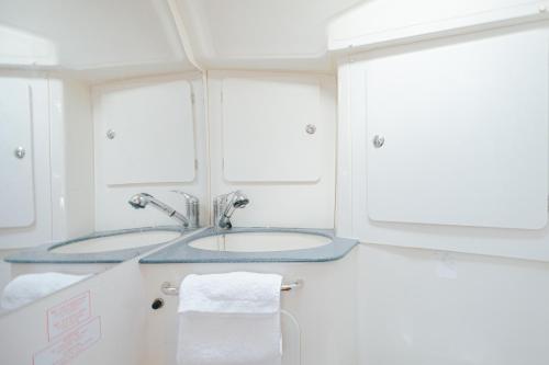 阿尔布费拉Stay in a Boat - Algarve (Blue Pearl)的一间带水槽的浴室和两个窗户