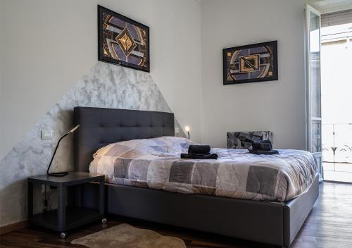 都灵Suite Mont Blanc nel Cuore di Torino的一间卧室配有一张床和一张桌子上的台灯
