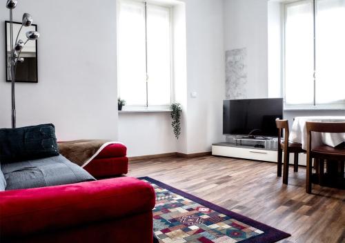 都灵Suite Mont Blanc nel Cuore di Torino的客厅配有红色沙发和平面电视